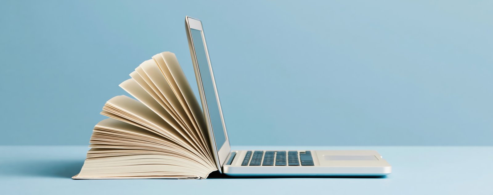 laptop with book connected to it